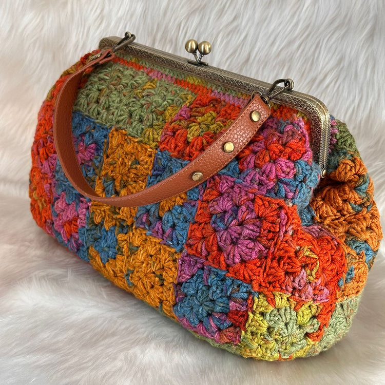 Colorful crocheted handbag with a brown strap
