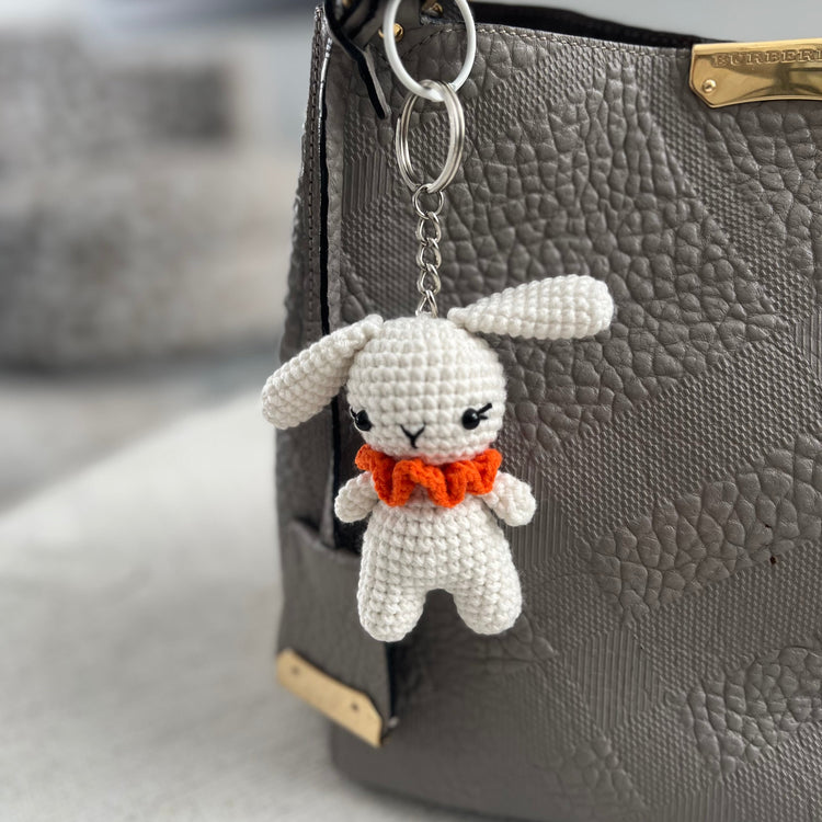 White crocheted bunny keychain with an orange bow