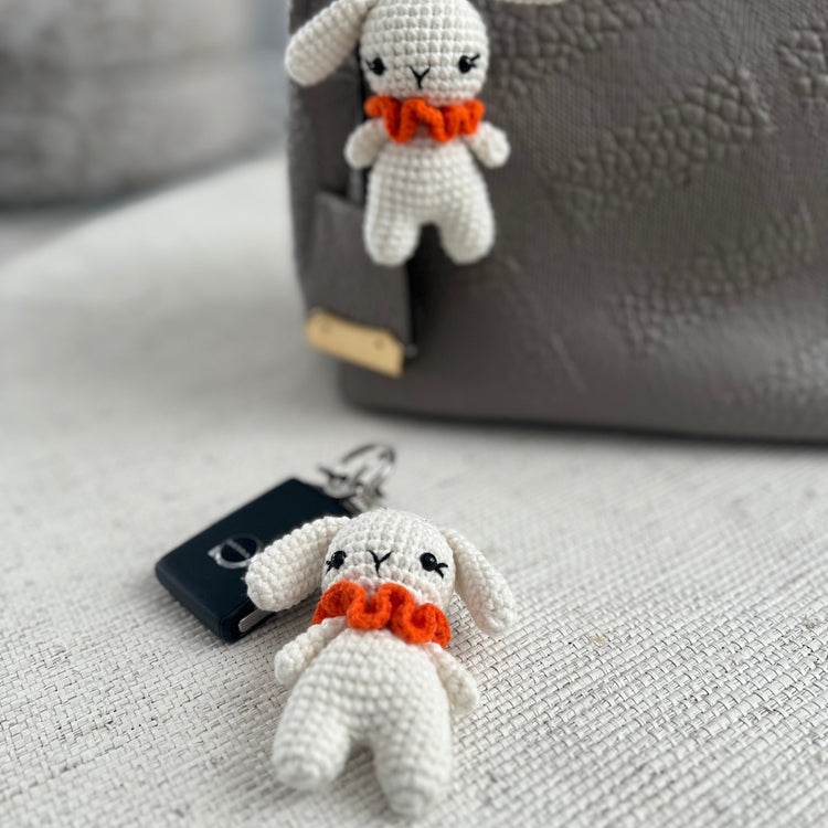 white crocheted bunny keychains with orange scarves