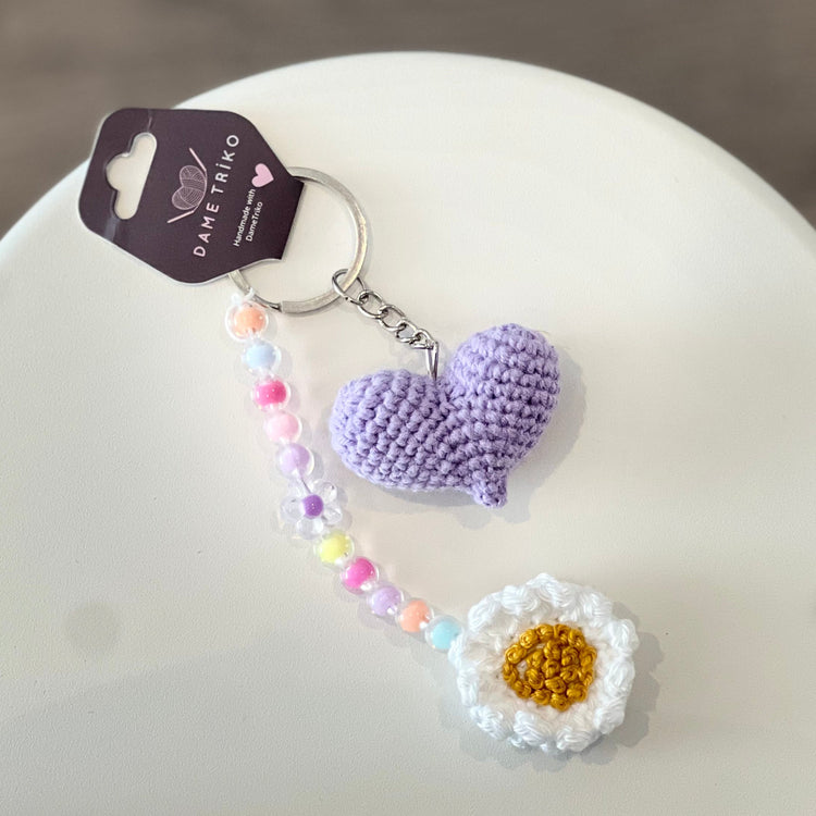 Keychain with purple hearts and a white flower