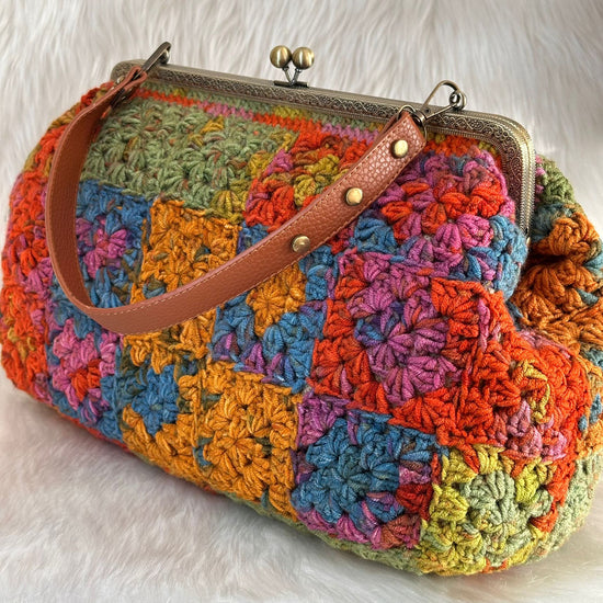 Colorful crocheted handbag with a brown leather strap