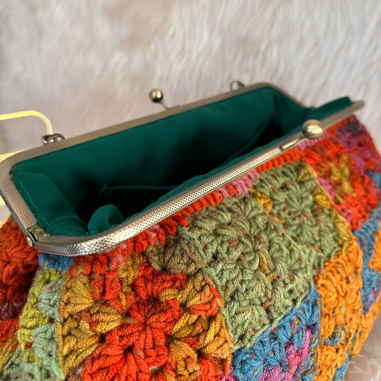 Colorful crocheted handbag with a green interior 